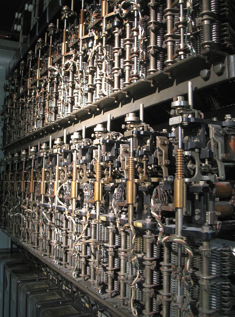 Ein Ausschnitt aus einem Regal, in dem dicht an dicht Bauteile aus elektromechanischen Komponenten montiert sind.