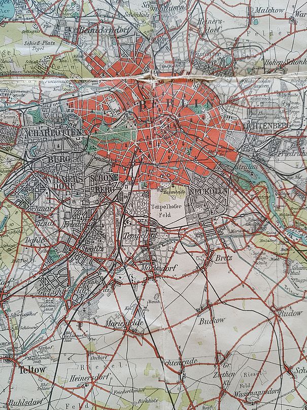 Eine Ausschnitt aus einer alten Landkarte. Die Berliner Innenstadt ist rot hervorgehoben und zeigt ein relativ gleichmäßiges Straßennetz. Heutige Randbezirke sind weit davon entfernte Dörfer.